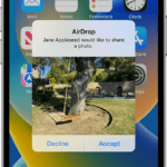 iPhone showing an incoming AirDrop, a photo of a tree swing, with options to decline or accept.  