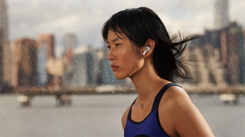 A woman wearing AirPods (3rd generation) in the rain.  