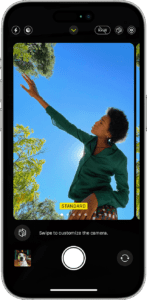 An iPhone showing Camera app with four people in the viewfinder  