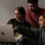 Three people looking at the 15-inch MacBook Air.