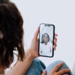 person holding iphone and engaged in video call  