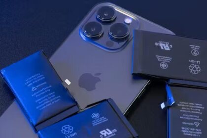 An iPhone 14 Pro Max on a desk with Lithium Ion batteries on top of it