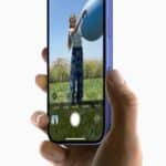 A user captures a photo of a person holding a ball with iPhone 16.