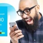 Man looking shocked at his iPhone, which has run out of remaining credit.