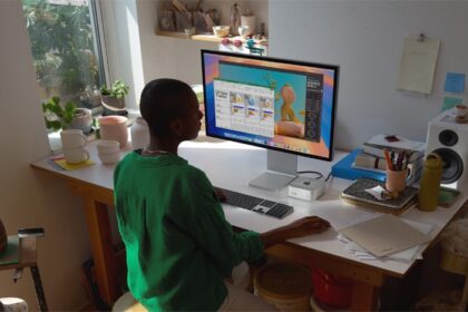 A Mac mini user works at a desk surrounded by ceramics pieces.