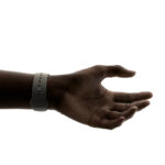 A hand wearing Apple Watch, with the thumb and index finger ready to make the double tap gesture.