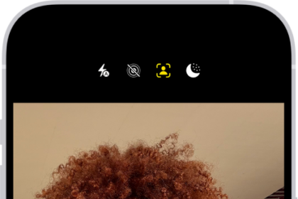 The Camera screen in Photo mode. Within the camera frame, the subjects are taking a selfie.
