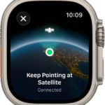 A screen showing a satellite icon over a curved view of Earth, a green connection indicator, and "Keep Pointing at Satellite" text.