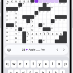 A partially filled crossword puzzle, with controls above it, and a keyboard open at the bottom.